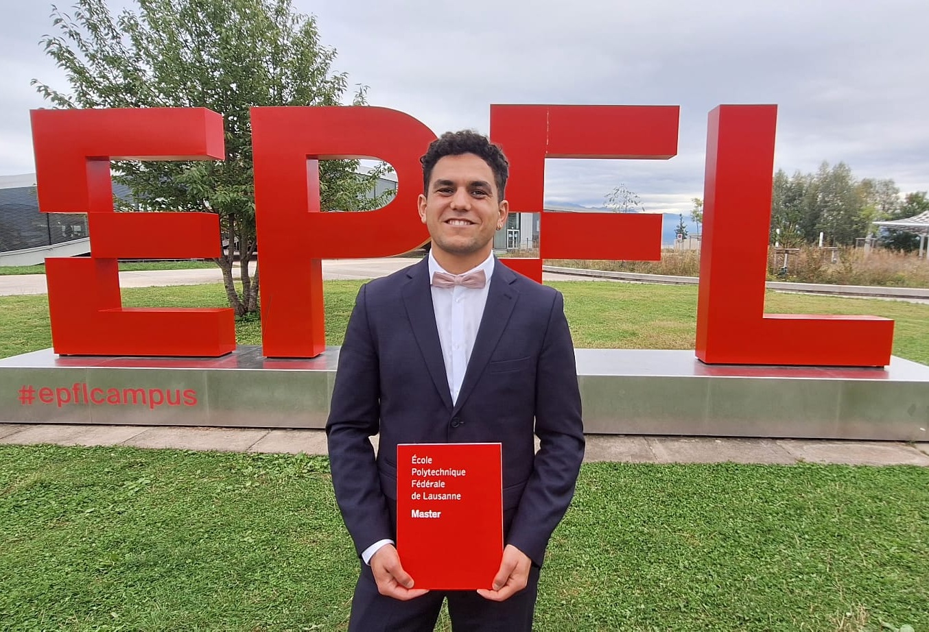 Diplôme de Master EPFL, devant la sculpture EPFL du campus